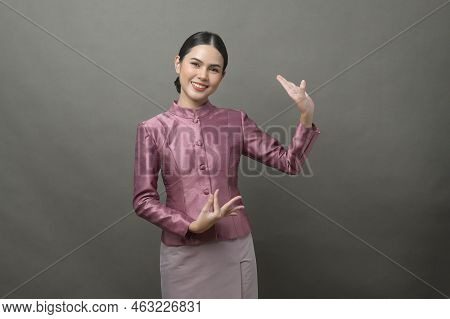 A Young Asian Woman Wearing Thai Traditional Cloth On Gray Background