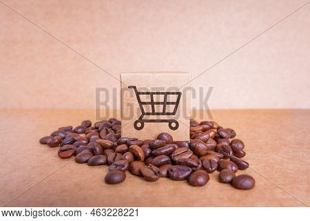 Tiny Cardboard Box With A Shopping Cart Icon Placed On Top Of A Pile Of Roasted Coffee Beans Isolate