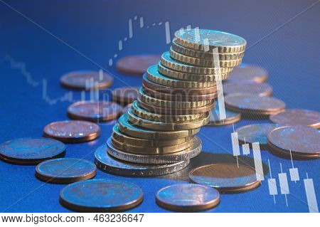 Stack Of Euro Coins And Market Chart Graph With Downward Trend, Loss Of Value. Soft Focus