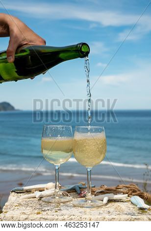Pouring Of Txakoli Or Chacolí Slightly Sparkling Very Dry White Wine Produced In The Spanish Basque