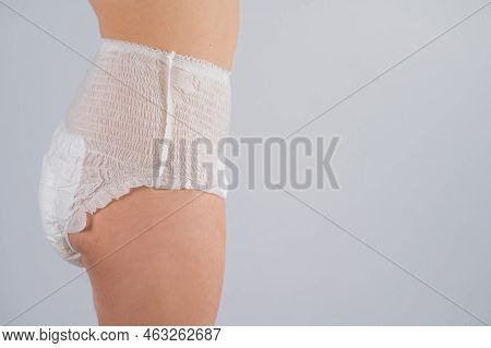 Side View Of A Woman In Adult Diapers On A White Background. Incontinence Problem.
