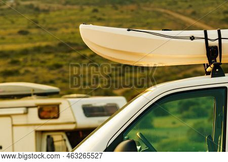 Car Van With Canoe On Top Roof Against Mountain Nature. Caravan In The Distance. Active Lifestyle, V