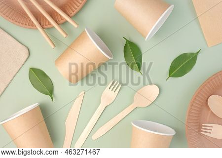 Eco - Friendly Tableware On Green Background. Top View. Plastic Free Set Of Brown Paper Utensil. Str