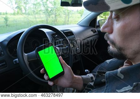 The Driver Got Lost In The Woods, Looking For Directions In The Phone, On A Green Screen. Space For 