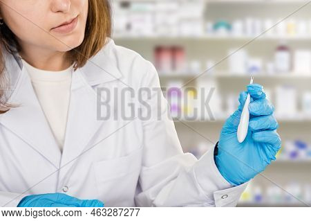 Young Woman Pharmacist With Thermometer Working In Pharmaceutical Shop, Closeup Photo