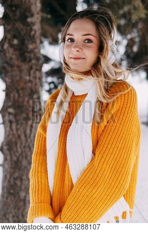 Teen Blonde In A Yellow Sweater Outside In Winter. A Teenage Girl On A Walk In Winter Clothes In A S