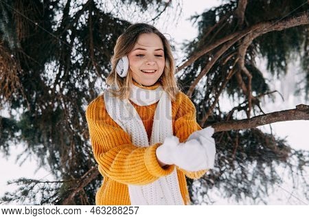 Teen Blonde In A Yellow Sweater Outside In Winter. A Teenage Girl On A Walk In Winter Clothes In A S