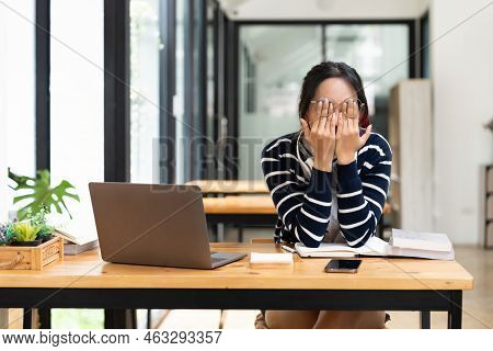 Tired Asian Male Student Sitting At Desk Using Laptop. Bored Youth Is Exhausted From Getting Ready F