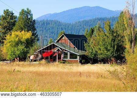 Alpine Meadow Surrounded By A Temperate Forest Including A Home On A Ranch Surrounded By Mountains T