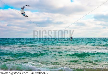 A Man Rolls On The Waves On A Board With A Parachute, Kitesurf On The Sea On An Autumn Cloudy Day. S