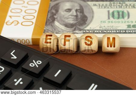 Business Concept. On A Brown Surface Are Dollars, A Calculator And Wooden Cubes With The Inscription
