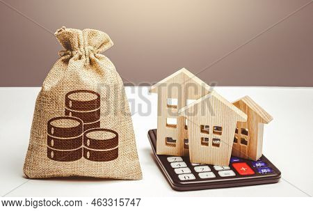 Houses On A Calculator And Coin Money Bag. Realty Or Rental Business. Real Estate Valuation. Buying 