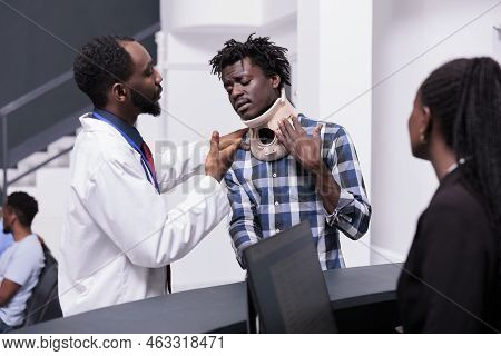 Doctor Consulting Patient With Neck Collar Foam To Cure Accident Injury, Receiving Healthcare Suppor