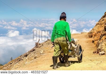 Miner Extracting Sulfur Inside The Crater Of Active Volcano Ijen, Java Island, Indonesia