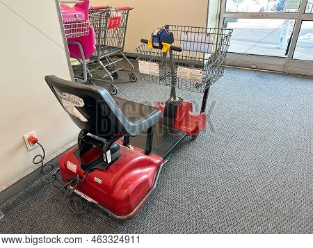 New Hope, Minnesota - October 11, 2022: Motorized Scooter With A Grocery Cart Attached, Getting Char