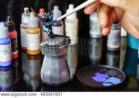 Person Painting A Small Role-playing Game Figure For Board Games.