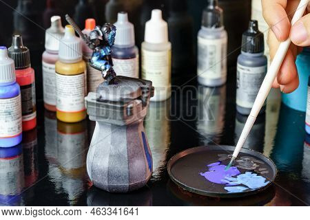 A Person Painting Figures Of Warriors Used To Participate In Role-playing Games Among Various Partic