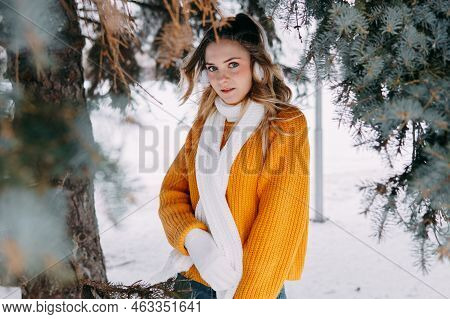 Teen Blonde In A Yellow Sweater Outside In Winter. A Teenage Girl On A Walk In Winter Clothes In A S