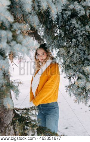 Teen Blonde In A Yellow Sweater Outside In Winter. A Teenage Girl On A Walk In Winter Clothes In A S