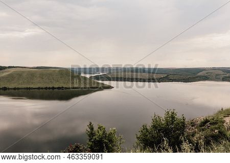 The Banks Of A Large River. Bakota, Dniester River, Ukraine. Smooth Calm Water Panoramic Landscape.