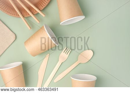 Eco - Friendly Tableware On Green Background. Top View. Plastic Free Set Of Brown Paper Utensil. Str