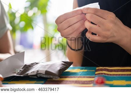 An Unrecognizable Person Rolling A Cigarette At Home