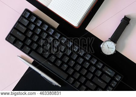 Small Compact Mechanical Computer Keyboard With 68 Keys On A Black And Pink Background Next To A Wri