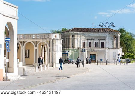 Tresigallo,italy-may 2, 2021:people Stroll Among The Arcades In Tresigallo During A Cloudy Day