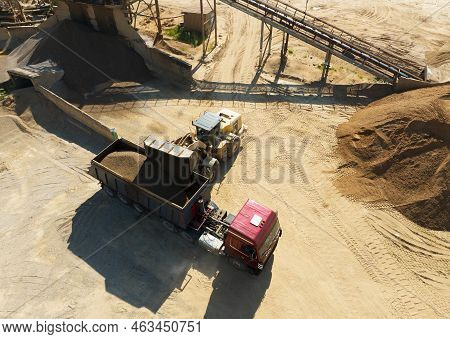 Wheel Loader Load Sand In Tipper Truck In Open Pit. Front End Loader On Earthworks In Open-pit Minin
