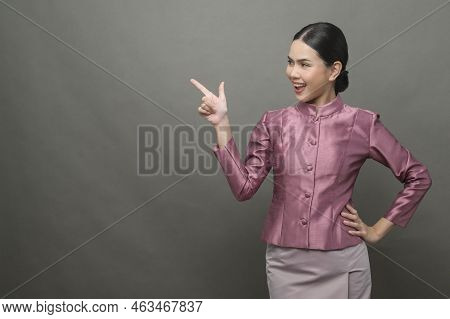 A Young Asian Woman Wearing Thai Traditional Cloth On Gray Background