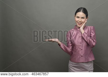 A Young Asian Woman Wearing Thai Traditional Cloth On Gray Background