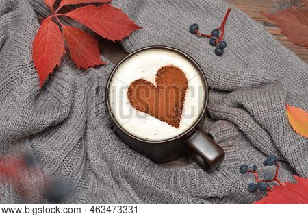 Cappuccino Cup With Heart Pattern And A Gray Sweater