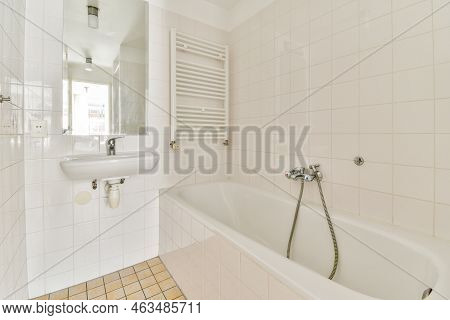 Shower And Free-standing Bathroom In Light Bathroom With Washing Machine