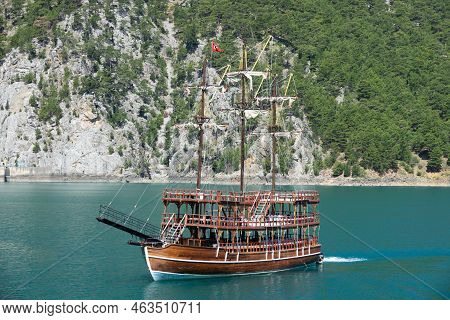 A Three-masted Tourist Yacht Floats On A Lake Among Mountain Cliffs Near The Oymapinar Dam. Green Ca