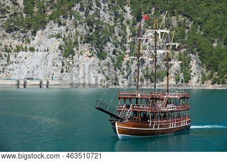 A Three-masted Tourist Yacht Floats On A Lake Among Mountain Cliffs Near The Oymapinar Dam. Green Ca