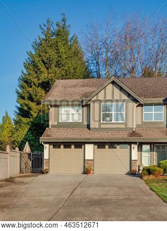 Double Garage Of Residential House With Concrete Driveway In Front