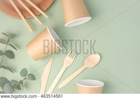 Eco - Friendly Tableware On Green Background. Top View. Plastic Free Set Of Brown Paper Utensil. Str