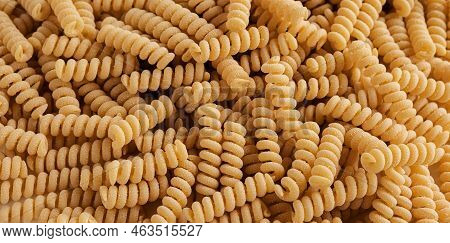 Gluten Free Cornmeal Pasta Wallpaper. Spiral Raw Macaroni From Corn And Rice Flour Rotating On Turnt