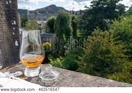 Glass Of Single Malt Scotch Whisky Served On Old Window Sill In Scottisch House With View On Old Par