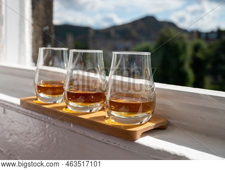 Flight Of Single Malt Scotch Whisky Served On Old Window Sill In Scottisch House With View On Old Pa