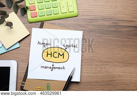 Paper With Hcm Abbreviation And Space For Text On Wooden Office Table, Flat Lay. Human Capital Manag