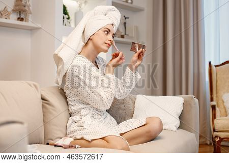 Woman Wearing Dressing Gown And Has A Towel On Her Hair Doing A Make Up