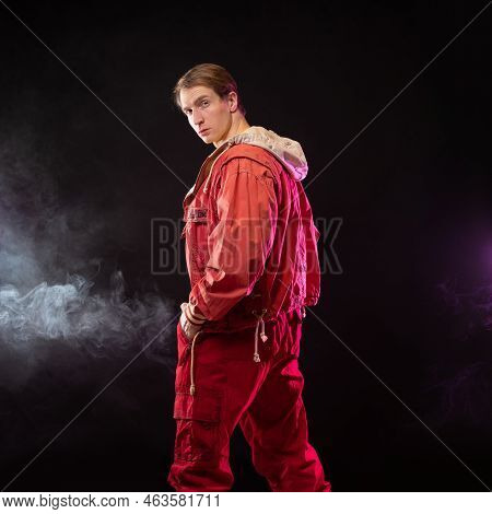 A Young Muscular Man In A Bright Outfit Poses In A Pretentious Pose, Style And Grotesque. Attractive