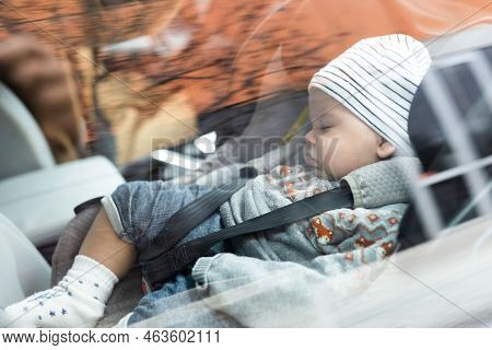 Cute Little Baby Boy Sleeping Strapped Into Infant Car Seat In Passenger Compartment During Car Driv