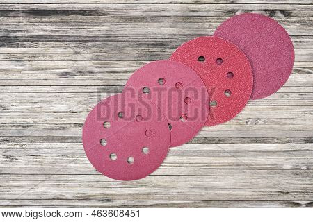 Round Sandpaper Discs For Orbital Sander. Adhesive Sanding Discs On A Wooden Background.