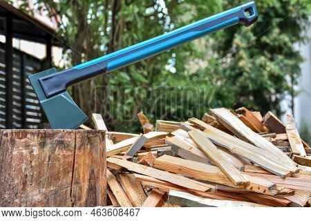 Axe On A Log For Chopping Wood With Chopped Firewood For Kindling A Wood Stove To Heat The House.