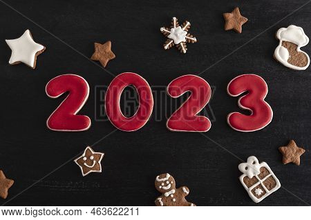 Inscription 2023 From Gingerbread Cookie. Christmas Bacing, Black Background.