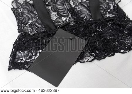 Black Lace Lingerie With Empty Black Tag On White Background. Transparent Lace Sexy Bralet. Copy Spa