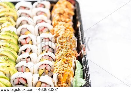 Pre-packaged Variety Of Sushi And Sushi Rolls In A Plastic Tray.