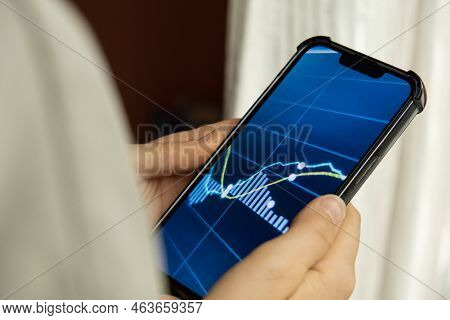 Female Hands Holding Phone, Checking Stock Market Graph For Tranding And Investment In Security Exch